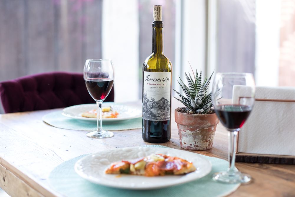 Lifestyle blogger Devin McGovern and wife Marlene Martinez in the kitchen with pizza and wine