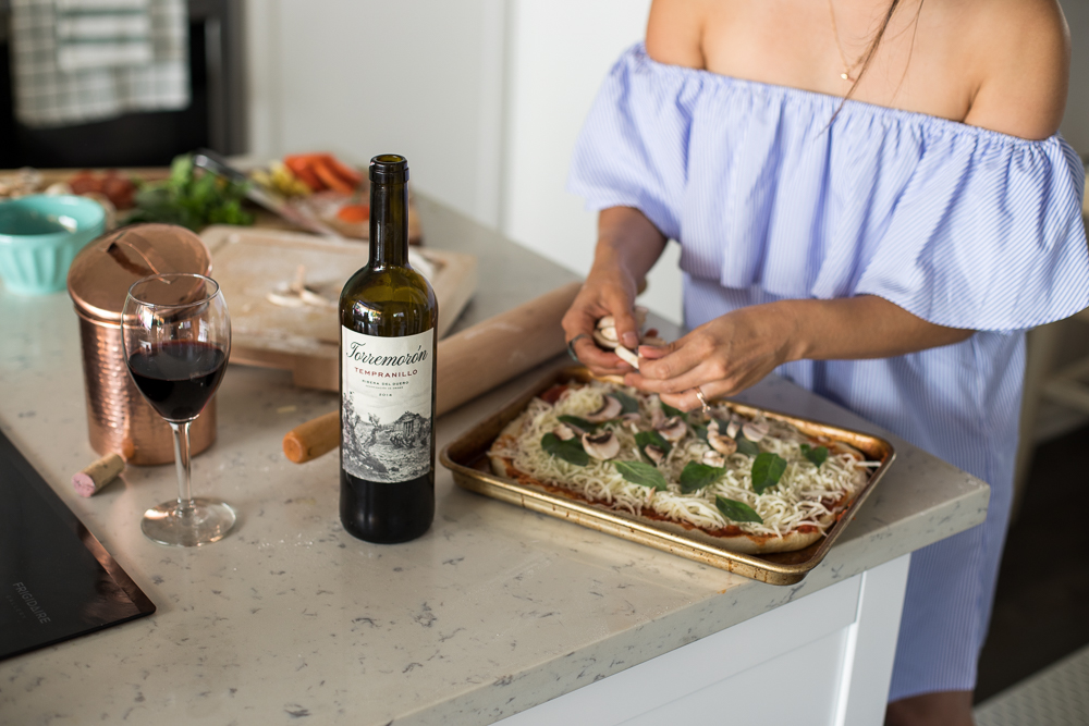 Lifestyle blogger Devin McGovern and wife Marlene Martinez in the kitchen with pizza and wine