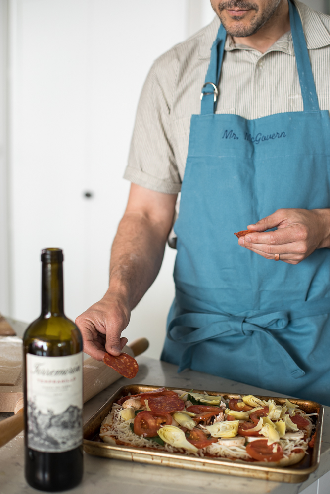 Lifestyle blogger Devin McGovern and wife Marlene Martinez in the kitchen with pizza and wine